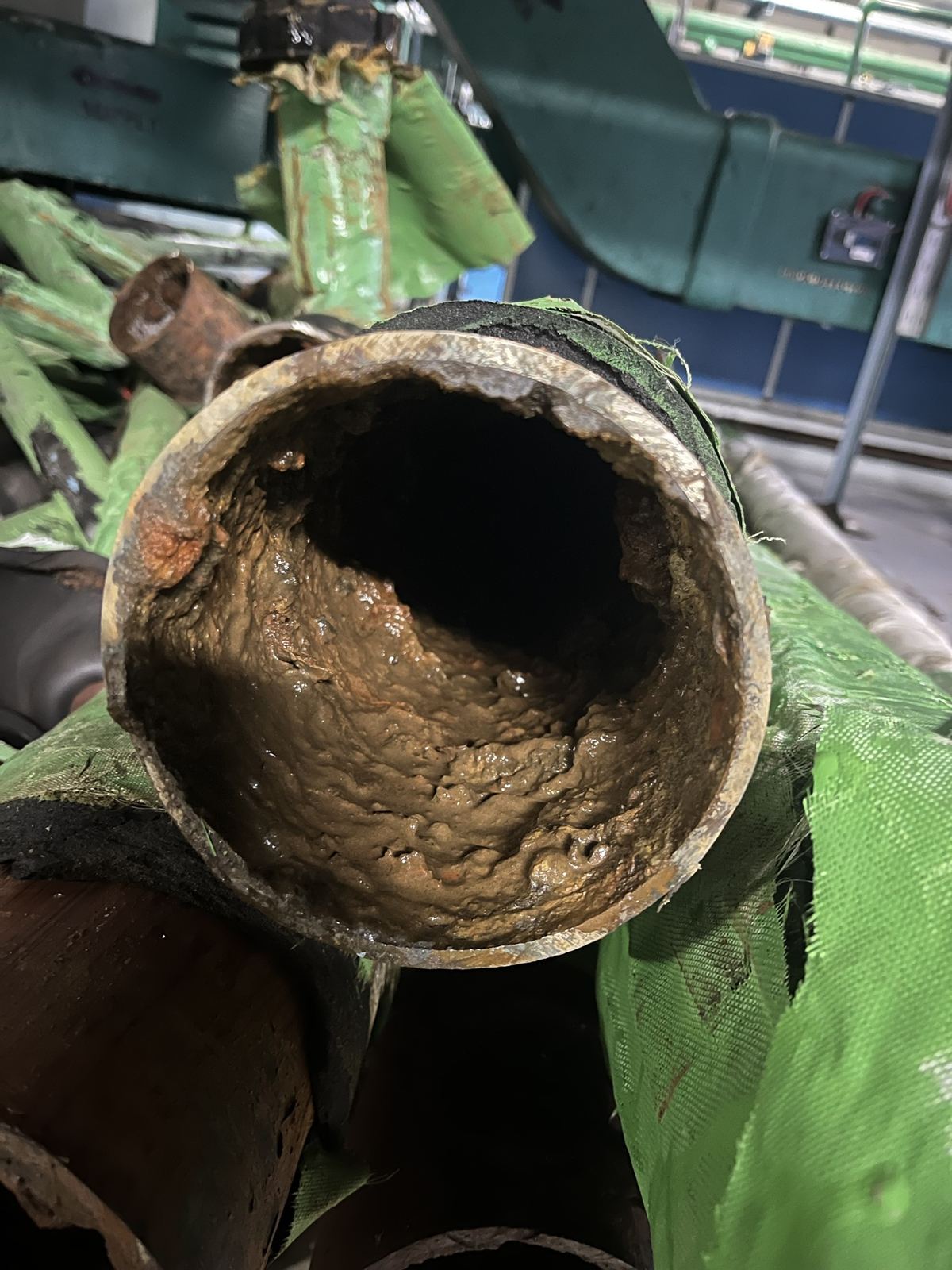 Inside of a corroded metal pipe removed from service, with the bore heavily scaled